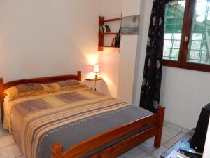 a bedroom with a bed in a room with a window at Sarl Mayoume in Mamoudzou