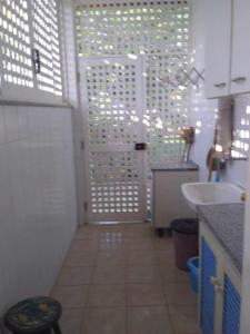 ein Badezimmer mit einer weißen Tür und einem Waschbecken in der Unterkunft Casa de Praia Itacimirim Bahia in Camassari