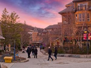 a group of people walking down a street at Modern Town at Wintergreen 2min walk to Village Sauna in Blue Mountains