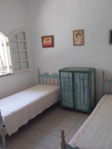 ein Schlafzimmer mit zwei Betten und einem Fenster in der Unterkunft Casa de Praia Itacimirim Bahia in Camassari