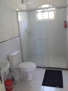ein Badezimmer mit weißer Toilette und Dusche in der Unterkunft Casa de Praia Itacimirim Bahia in Camassari