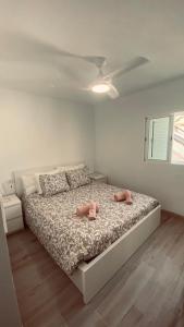 Un dormitorio con una cama con dos zapatos rosados. en CASA TONINO, en Mogán