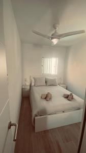 a white bedroom with a bed with a ceiling at CASA TONINO in Mogán