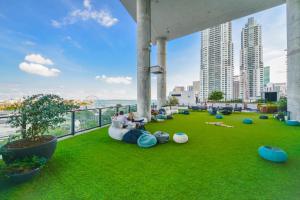 - un balcon avec des personnes assises sur un canapé sur l'herbe dans l'établissement Charming Studio Apartment in an Exclusive Oasis, à Miami