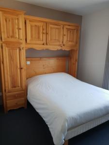 PéronにあるAuberge Communale de la Fruitièreのベッドルーム1室(ベッド1台付)、木製キャビネットが備わります。