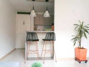 a kitchen with two bar stools and a counter at Lugar acogedor in Piedecuesta