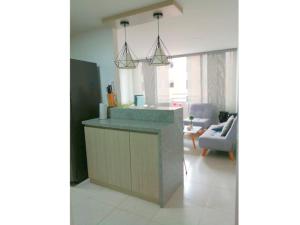 a kitchen with a counter and a living room at Lugar acogedor in Piedecuesta