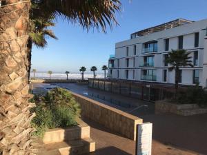 budynek obok plaży z palmą w obiekcie Luxury Ocean View Apartment - Anfa Place - w mieście Casablanca