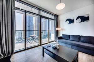 een woonkamer met een bank en een groot raam bij Palace Residences, Dubai Creek Harbour in Dubai