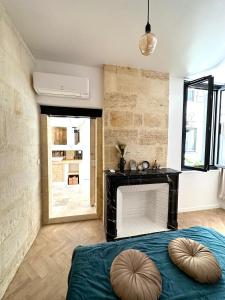a bedroom with a fireplace and a blue bed at Charmante Maison La Libournaise +parking in Libourne