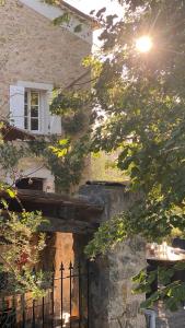 uma casa de pedra com uma janela e uma cerca em Villa Mas de la Roche em Fayence
