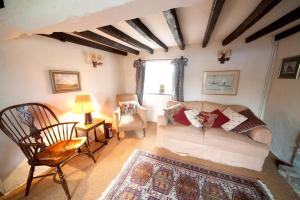 uma sala de estar com um sofá e uma cadeira em Afton Thatch: Beautiful Thatched Family Cottage em Freshwater