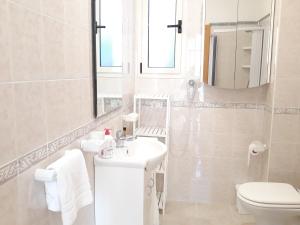 a white bathroom with a sink and a toilet at Residence Maresol in Vieste