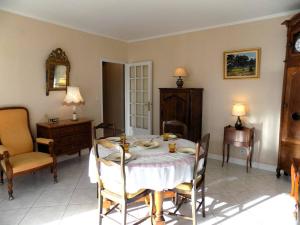- une salle à manger avec une table et des chaises dans l'établissement Royan - Résidence VILLA BRACELLI - APPARTEMENT SPACIEUX - Centre-ville, à Royan