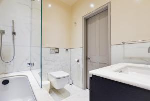 a bathroom with a tub and a toilet and a sink at Soho Luxury 1 Bedroom Apartment by Concept Apartments in London