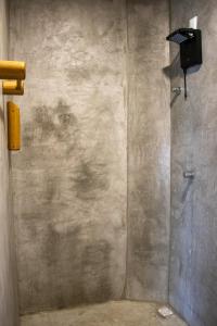 a bathroom with a shower with a television on the wall at Pousada Veleiro Kite Preá in Prea