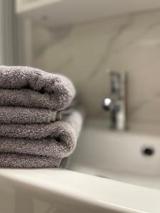 a pile of towels sitting on top of a bathroom counter at T2D Apartment - Suite BLG proche Disneyland Paris in Bussy-Saint-Georges