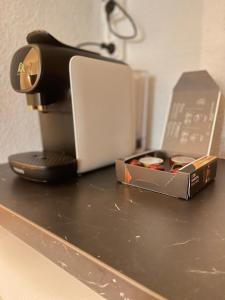 a coffee maker and a box on a counter at T2D Apartment - Suite BLG proche Disneyland Paris in Bussy-Saint-Georges