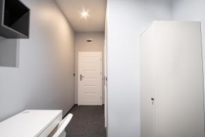 a small bathroom with a white door and a toilet at Prywatny pokój z prywatną łazienką - Senatorska 36 in Łódź