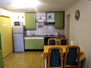 una cocina con armarios verdes, mesa y sillas en Leo, en Makarska