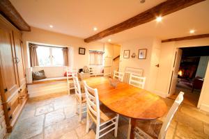 uma sala de jantar com uma mesa de madeira e cadeiras em Afton Thatch: Beautiful Thatched Family Cottage em Freshwater