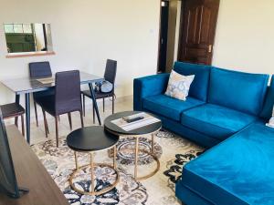 STUDIO MAIYAN في Busia: غرفة معيشة مع أريكة زرقاء وطاولة