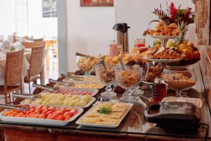 un buffet con muchos tipos diferentes de comida en una mesa en Hotel Girassol da Serra, en Santa Maria Madalena