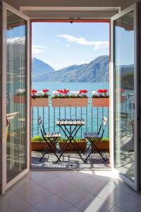 een balkon met een tafel en uitzicht op het water bij Deluxe finestra sul lago in Bellano