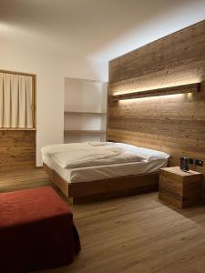 una camera con un grande letto e una parete in legno di Chalet Baita del Sole a Teglio