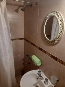 y baño con lavabo y espejo. en Hosteria Catalina en Villa Carlos Paz