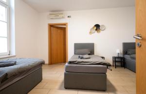 2 camas individuales en una habitación con puerta en Work & Stay Apartment Bedburg Hau en Bedburg Hau