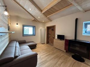 ein Wohnzimmer mit einem Sofa und einem Flachbild-TV in der Unterkunft Appartamento Chalet Bernardi in Caderzone