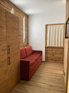 a living room with a red couch in a room at Chalet Baita del Sole in Teglio +21 photos