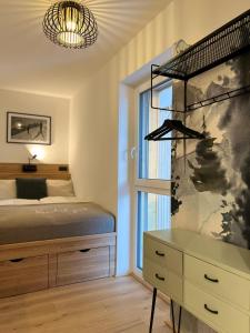 a bedroom with a bed and a dresser and a window at Das Genner - Boutique Appartement in Tauplitz +30 photos