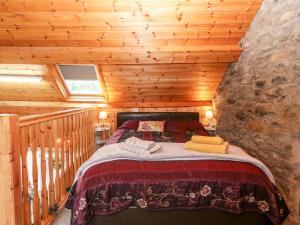 a bedroom with a bed in a log cabin at Yr Hen Efail in Welshpool