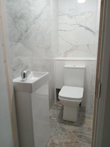 a white bathroom with a toilet and a sink at Good priced double bed rooms in harrow with shared bathrooms in Hatch End