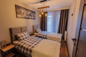 a bedroom with two beds and a window at Apartamenty DeLux Centrum Kielce in Kielce