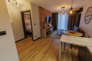 a living room with a table and a living room with a couch at Apartamenty DeLux Centrum Kielce in Kielce