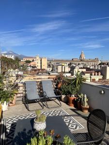 un patio con sedie e tavoli su un balcone di Trìcora Sicilian B&B a Catania