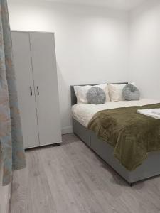 ein Schlafzimmer mit einem Bett und einem weißen Schrank in der Unterkunft Good priced double bed rooms in harrow with shared bathrooms in Hatch End