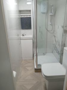 y baño blanco con ducha y aseo. en Good priced double bed rooms in harrow with shared bathrooms en Hatch End