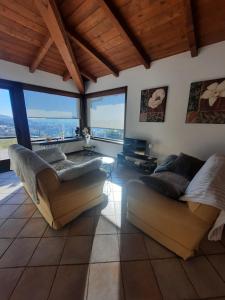 a living room with two couches and large windows at Villa Duno a un passo da Città Alta in Clanezzo