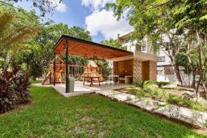 a backyard with a play structure and a playground at New Modern Condo in Playa del Carmen in Playa del Carmen