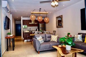 a living room with a couch and a kitchen at New Modern Condo in Playa del Carmen in Playa del Carmen