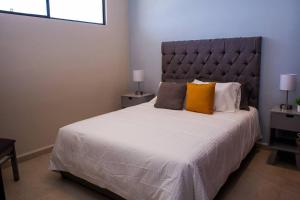 a bedroom with a large white bed with orange pillows at New Modern Condo in Playa del Carmen in Playa del Carmen +17 photos