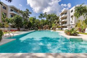 a swimming pool in front of a apartment building at New Modern Condo in Playa del Carmen in Playa del Carmen