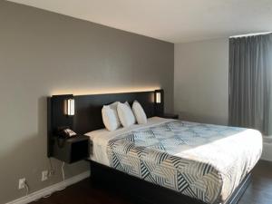 1 dormitorio con 1 cama grande con sábanas y almohadas blancas en Motel 6 Port Lavaca, TX, en Port Lavaca