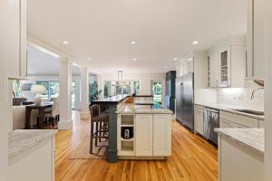 a large kitchen with white cabinets and a counter top at 335 Winged Foot in Kiawah Island