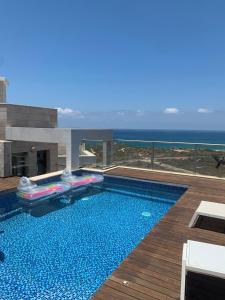 a swimming pool with a view of the ocean at הקומה ה 16 POOL PENTHAUSE in H̱adera