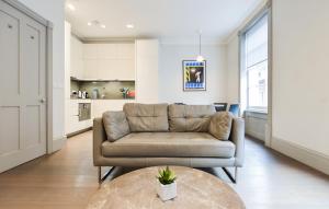 a living room with a couch and a table at Soho Deluxe 1 Bedroom Apartment by Concept Apartments in London
